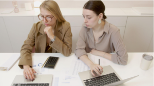 two women with laptops
